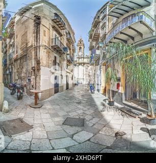 Scena di strada della città siciliana di Palermo, che mostra una strada deserta fiancheggiata da vecchie case in parte fatiscenti durante il giorno Foto Stock