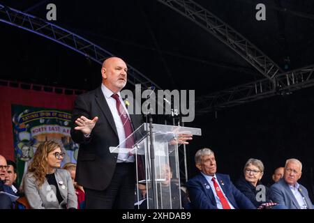 Durham, Regno Unito. 13 LUGLIO 2024. Mick Whelan, generale sec per ASLEF, si rivolge alla folla mentre migliaia di persone sono scese in strada per celebrare il gala dei minatori di Durham, nonostante un diluvio di pioggia durante tutto il giorno. Credito Milo Chandler/Alamy Live News Foto Stock