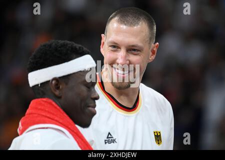 Amburgo, Germania. 13 luglio 2024. Basket: Partita internazionale, Germania - Paesi Bassi, Barclays Arena. Il tedesco Daniel Theis (r) e Dennis Schröder stanno insieme durante un time-out. Crediti: Gregor Fischer/dpa/Alamy Live News Foto Stock