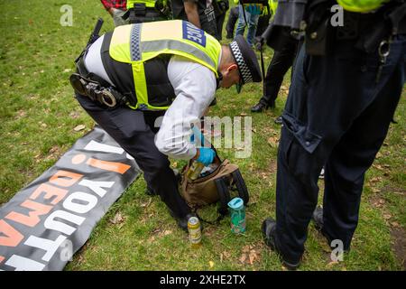 Londra, Regno Unito. 13 luglio 2024. Un agente di polizia perquisisce una borsa di un dimostratore di richieste giovanili durante la manifestazione. Una dimostrazione della domanda giovanile si è tenuta a Russell Square. Una sezione 11 della legge sull'ordine pubblico è stata emessa dalla polizia metropolitana che consente agli agenti di perquisire chiunque all'interno di un'area prescritta. Credito: SOPA Images Limited/Alamy Live News Foto Stock