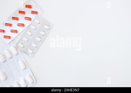 Capsule mediche rosse e bianche confezionate in blister isolato su sfondo bianco. Striscione orizzontale, spazio di copia. Pillole, farmacia, trattamento, assistenza sanitaria. Foto Stock