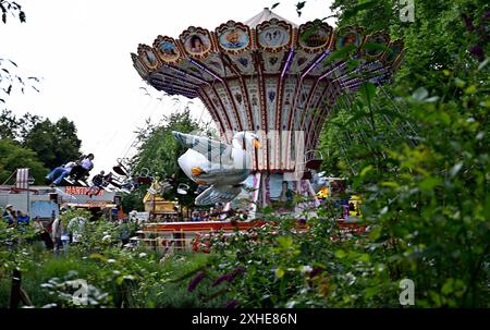 Impressionen,Fotos von der Mölmschen Kirmes in Mülheim an der Ruhr,Stadt im Ruhrgebiet im Bundesland Nordrhein-Westfalen NRW ,Deutschland.Kirmesvergnügen,Jahrmarkt,Rummelplatz,Volksfest,Schausteller,Attraktionen,Schausteller. Fahrgeschäft Kettenkarussell mit fliegendem Schwan,fotografiert am 13.07.2024. Die Fotos stehen nur für redaktionelle,journalistische Zwecke/Verwendung/Nutzung zur Verfügung. Â *** impressioni,foto della Mölmsche Kirmes a Mülheim an der Ruhr,città della Ruhr nello stato federale della Renania settentrionale-Vestfalia NRW,fiera funebre della Germania,fiera,fiera,fiera,festa popolare,showmen, Foto Stock