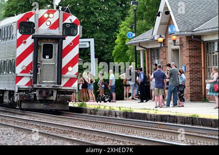 Glen Ellyn, Illinois, Stati Uniti. I passeggeri dei pendolari in attesa si riuniscono mentre il treno Metra diretto a Chicago arriva alla stazione locale dei pendolari. Foto Stock