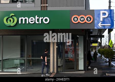 Segnaletica Woolworths Metro e BWS, insieme a un cartello blu P con la freccia che indica il parcheggio vicino, sopra l'entrata dei negozi di recente apertura Foto Stock