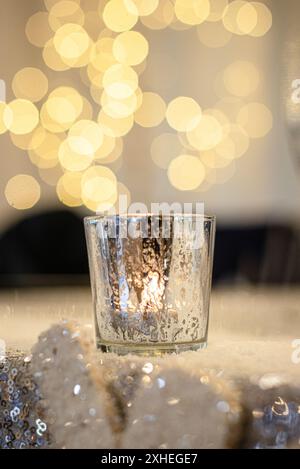 Candela dorata su superficie glitter con sfondo bokeh rotondo verticale Foto Stock