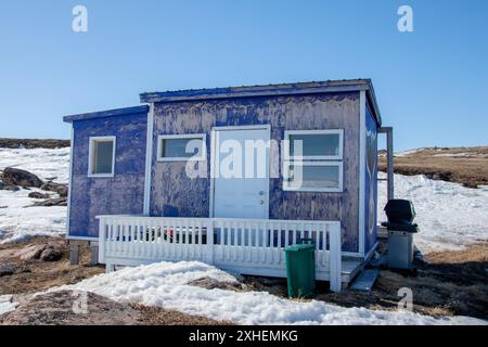 Capanne e capannoni nel campo di caccia/pesca sulla spiaggia di Frobisher Bay ad Apex, Nunavut, Canada Foto Stock