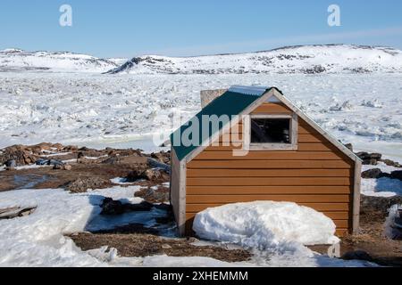 Capanne e capannoni nel campo di caccia/pesca sulla spiaggia di Frobisher Bay ad Apex, Nunavut, Canada Foto Stock