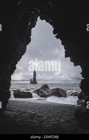 Vista sulla riva dall'interno di una grotta sulla spiaggia di sabbia nera di Reynisfjara. Foto Stock