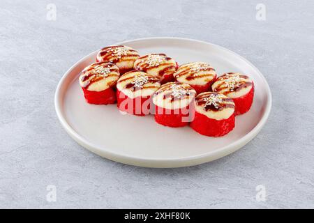 Sushi al forno con salmone in caviale, guarnito con salsa unagi e semi di sesamo Foto Stock