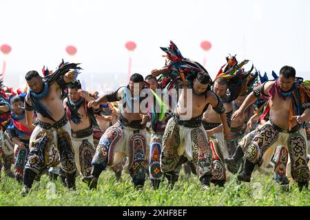 Xilin Gol, la regione autonoma della Mongolia interna cinese. 14 luglio 2024. Lottatori di tradizionale stile mongolo si esibiscono durante la cerimonia di apertura del 34° festival Naadam nella Xilin Gol League, regione autonoma della Mongolia interna della Cina settentrionale, 14 luglio 2024. Il festival di Naadam è iniziato qui domenica. Naadam, solitamente tenuto a metà estate e talvolta in inverno nelle aree pastorali della Mongolia interna, significa "giochi" nella lingua mongola. Spesso comprende lotta, tiro con l'arco e corse di cavalli, noti anche come i "tre Giochi degli uomini". Crediti: BEI He/Xinhua/Alamy Live News Foto Stock