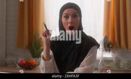 Donna araba ragazza d'affari indiana musulmana donna islamica padrona di casa in hijab laptop penna notebook pensiero soluzione meditare pensare come Foto Stock