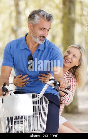 coppia matura che va a fare un giro in bicicletta in città Foto Stock