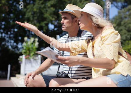 litigare con una coppia seduta su una panchina in un parco Foto Stock