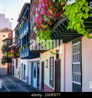 Balconi in legno da cui pendono piante fiorite sul lungomare dell'isola di la Palma, Isole Canarie. Foto Stock