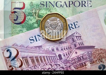 Moneta e banconote in dollari singaporiani come sfondo. Foto Stock