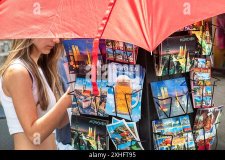 Touristin auf der Suche nach einer schönen München-Postkarte, negozio di souvenir a der Innenstadt, München, Juli 2024 Deutschland, München, Juli 2024, Touristin sucht hübsche München-Postkarte, un negozio di souvenir einem a der Innenstadt, Tourismus, Bayern *** turista alla ricerca di una bella cartolina di Monaco, negozio di souvenir nel centro della città, Monaco di Baviera, luglio 2024 Germania, Monaco di Baviera, luglio 2024, turista alla ricerca di una bella cartolina di Monaco, in un negozio di souvenir nel centro della città, Turismo, Baviera Foto Stock