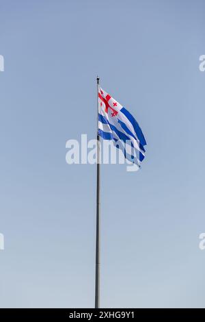 Adjara bandiera con croci rosse su bianco che sventolano contro il cielo azzurro, Adjara è una repubblica autonoma all'interno della Georgia. Foto Stock