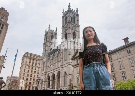 Un cinese in piedi di fronte alla storica cattedrale di notre dame a Montreal in Canada in un giorno coperto. Foto Stock