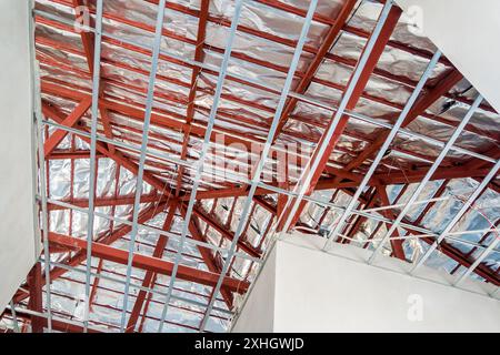 Installare il telaio in metallo per il soffitto del pannello in cartongesso nella casa in costruzione Foto Stock