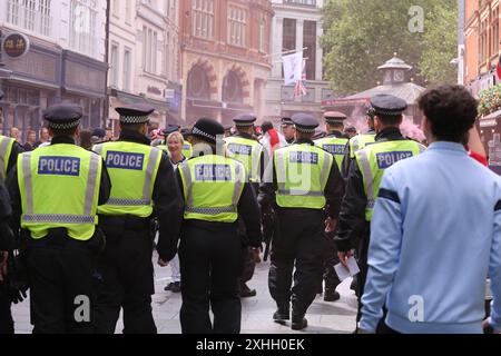 14 luglio 2024, Londra, UK Police Control fischiava i tifosi inglesi nel centro di Londra nel giorno della finale Inghilterra-Spagna della Coppa dei campioni, i tifosi si riuniscono e bevono nel centro di Londra. Un gruppo è stato respinto dalla Charring Cross Road e contenuto a Leicester Square, e ha fatto confiscare l'alcol secondo le leggi di Londra sull'alcol di strada. Foto: Roland Ravenhill/Alamy Foto Stock