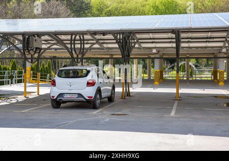 Uzhhorod, Ucraina - 4 aprile 2024: Stepway Renault Sandero bianca parcheggiata in un parcheggio coperto con pannelli solari. Foto Stock