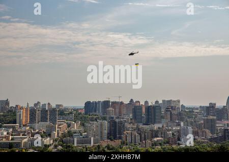 Kiev, Ucraina - 22 agosto 2021: Paesaggio urbano estivo aereo con elicottero militare volante mi-8 con bandiera Ucraina sventolata durante la parata dedic Foto Stock