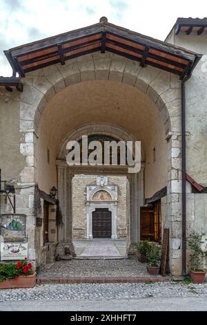 Porta d'accesso alle mura del complesso abbaziale benedettino di Farfa, con la basilica sullo sfondo. Abbazia di Farfa, Fara in Sabina, Lazio Foto Stock