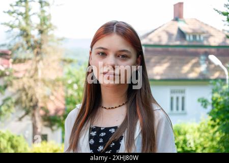 Ritratto di una bella ragazza adolescente con i capelli rossi sorridenti per strada Foto Stock