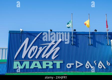 Insegna bilingue per i grandi magazzini North Mart in inglese e Inuktitut sulla Queen Elizabeth Way a Iqaluit, Nunavut, Canada Foto Stock