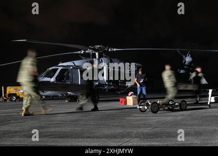 I marinai della US Navy assegnati all'Helicopter Sea Combat Squadron (HSC) 21 e all'HSC-23, Naval Air Station North Island, San Diego, caricano un Airborne Mine Neutralization System su un MH-60S Seahawk durante l'esercitazione Rim del Pacifico 2024, Hawaii, 12 luglio. Ventinove nazioni, 40 navi di superficie, tre sottomarini, 14 forze terrestri nazionali, più di 150 aerei e 25.000 membri del personale partecipano al RIMPAC nelle e intorno alle isole Hawaii, dal 27 giugno al 1 agosto. Il RIMPAC, la più grande esercitazione marittima internazionale al mondo, offre un'opportunità di formazione unica promuovendo e sostenendo la cooperazione Foto Stock