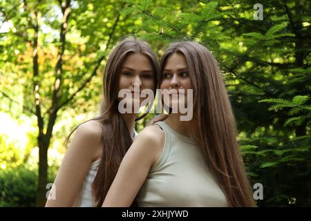 Ritratto di due bellissime sorelle gemelle nel parco Foto Stock