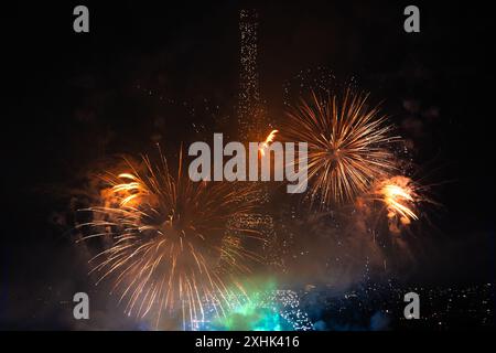 Parigi, Francia. 14 luglio 2024. I fuochi d'artificio esplodono vicino alla Torre Eiffel durante le celebrazioni della Festa della Bastiglia a Parigi, Francia, 14 luglio 2024. La Francia ha tenuto le celebrazioni della giornata nazionale francese, o Festa della Bastiglia, domenica. Crediti: Xu Chang/Xinhua/Alamy Live News Foto Stock