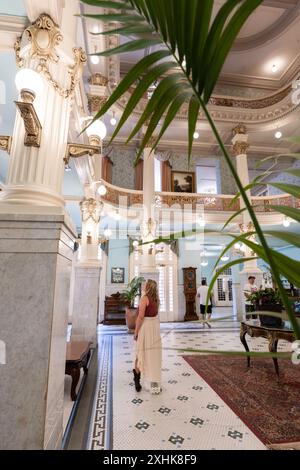 Le donne ospiti camminano intorno all'atrio della hall dorata dove persone famose socializzavano in passato, lo storico Menger Hotel, San Antonio, Texas, USA Foto Stock