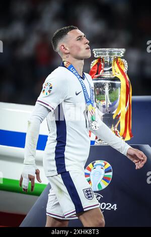 Berlino, Germania. 14 luglio 2024. L'inglese Phil Foden supera il trofeo durante la cerimonia di premiazione dopo la finale di UEFA Euro 2024 tra Inghilterra e Spagna a Berlino, in Germania, il 14 luglio 2024. Crediti: Pan Yulong/Xinhua/Alamy Live News Foto Stock