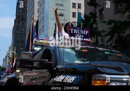 New York, New York, Stati Uniti. 14 luglio 2024. Un sostenitore di Trump con il cartello "Trump 2024 Take America Back" passa davanti alla Trump Tower sulla 5th Avenue in un SUV a un raduno che celebra l'ex presidente Donald Trump il giorno dopo essere stato colpito da un colpo di pistola mentre parlava ad un raduno della Pennsylvania. (Credit Image: © Edna Leshowitz/ZUMA Press Wire) SOLO PER USO EDITORIALE! Non per USO commerciale! Foto Stock