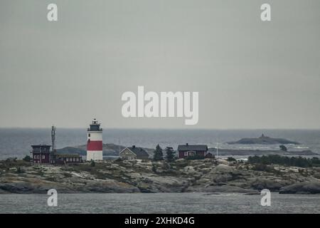 Die Schären vor Stockholm. Blick auf den Leuchtturm in der Einfahrt zu den Schäreninseln. Der Stockholmer Schärengarten besteht aus ungefähr 30 000 Inseln, Schären und Felsen, die sich 80 km östlich vom Stadtzentrum in Die Ostsee erstrecken. Einige sind große, bewohnte Inseln, die für ihre lebhaften Sommerpartys bekannt sind, andere ähneln eher felsigen Außenposten oder Gras bewachsenen Kuppen, die von Seehunden oder Kajakfahrern okkupiert werden. Stockholm Schweden *** l'arcipelago al largo di Stoccolma Vista del faro all'ingresso delle isole dell'arcipelago, l'arcipelago di Stoccolma con Foto Stock