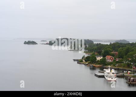 Die Schären vor Stockholm. Blick auf das ehemalige Sommerhaus von Astrid Lindgren Stenhällen auf der Schäreninsel Furusund. Die Insel War früher ein Kurort für wohlhabende Stockholmer Der Stockholmer Schärengarten besteht aus ungefähr 30 000 Inseln, Schären und Felsen, die sich 80 km östlich vom Stadtzentrum in die Ostsee erstrecken. Einige sind große, bewohnte Inseln, die für ihre lebhaften Sommerpartys bekannt sind, andere ähneln eher felsigen Außenposten oder Gras bewachsenen Kuppen, die von Seehunden oder Kajakfahrern okkupiert werden. Stoccolma Schweden *** l'arcipelago al largo di Stoccolma vi Foto Stock