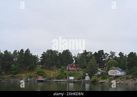 Die Schären vor Stockholm. Blick über die kleinen Inseln. Der Stockholmer Schärengarten besteht aus ungefähr 30 000 Inseln, Schären und Felsen, die sich 80 km östlich vom Stadtzentrum in Die Ostsee erstrecken. Einige sind große, bewohnte Inseln, die für ihre lebhaften Sommerpartys bekannt sind, andere ähneln eher felsigen Außenposten oder Gras bewachsenen Kuppen, die von Seehunden oder Kajakfahrern okkupiert werden. Stoccolma Schweden *** l'arcipelago al largo di Stoccolma Vista delle piccole isole l'arcipelago di Stoccolma è composto da circa 30.000 isole, scogli e rocce che si estendono per 80 km a est Foto Stock