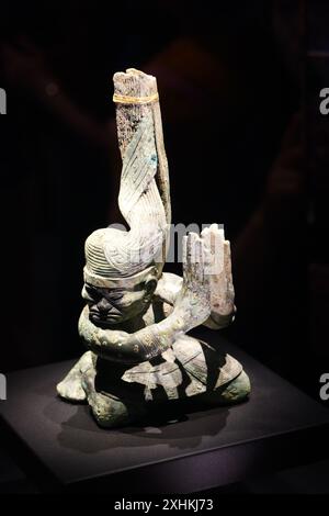 Guanghan Cina - 24 maggio 2024: Una figura in bronzo inginocchiata del XII secolo a.C. in mostra al Museo Sanxingdui, provincia del Sichuan in Cina. Il Foto Stock