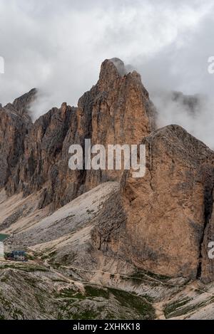 Rifugio Antermoia con Testone del Rifugio e vette più alte della Croda del Lago sopra il colle Mantel nelle Dolomiti durante le nuvolose d'estate Foto Stock