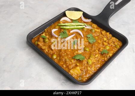 Il famoso piatto indiano Mutton matar Kheema Pav o Khima Paav è un curry di carne di capra macinata. Il keema di montone viene cotto con cipolla, pomodori e patate. Foto Stock