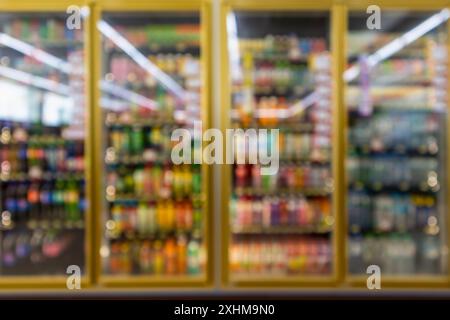 frigoriferi per minimarket con bottiglie di bibite analcoliche sugli scaffali, sfondo abstract sfocato Foto Stock