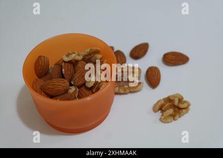 Mandorla in ciotola arancione su sfondo bianco Foto Stock