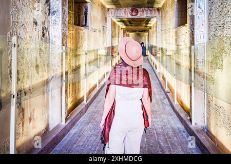 Donna elegante con cappello che ammira geroglifici e dipinti, Egitto Foto Stock