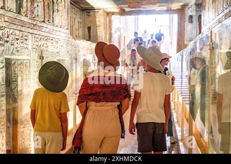 Donna matura con due ragazzi carini che visitano la Tomba di Ramses IX, Egitto Foto Stock