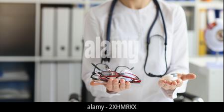 Primo piano di una dottoressa che fa la scelta tra lenti a contatto e occhiali. Oftalmologo, oftalmologia e concetto di correzione della visione Foto Stock