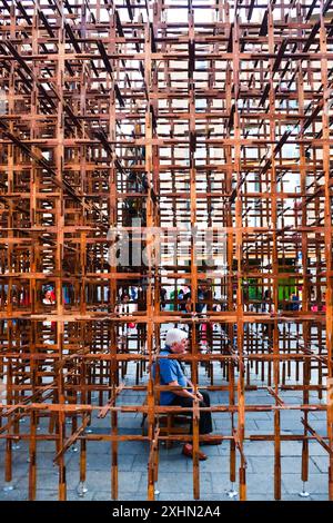 Uomo seduto all'interno di una scultura di arte contemporanea in metallo, all'aperto, Barcellona, Catalogna, Spagna, Europa Foto Stock