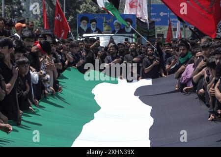 Srinagar, Jammu e Kashmir, India. 15 luglio 2024. I musulmani sciiti del Kashmir detengono una bandiera palestinese e gridano slogan pro-Palestina mentre partecipano a una processione l'ottavo giorno di Muharram, il primo mese del calendario islamico, a Srinagar. (Immagine di credito: © Adil Abass/ZUMA Press Wire) SOLO PER USO EDITORIALE! Non per USO commerciale! Foto Stock