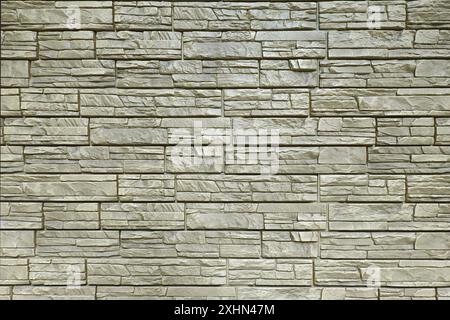 Parete coperta da pannelli in mattoni decorativi beige che rifiniscono la vista frontale orizzontale della foto Foto Stock