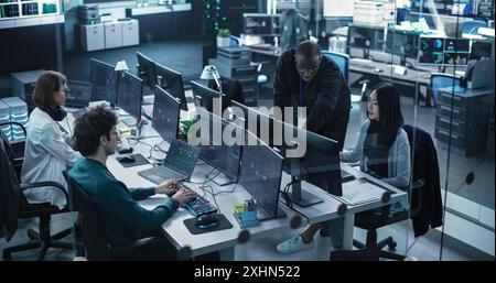 Gruppo di uomini e donne multiculturali che lavorano in un centro di ricerca, utilizzano computer per eseguire software avanzati, sviluppano l'interfaccia di intelligenza artificiale e la blockchain di cloud computing Foto Stock